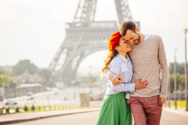 A couple walking by the Eiffel Tower in Paris