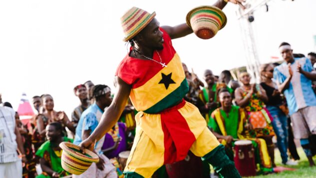 man in costume and hat dancing to ghana music