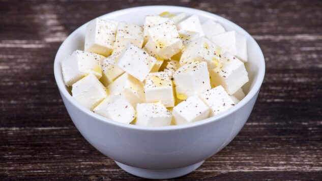 Feta cheese in bowl on wooden desk