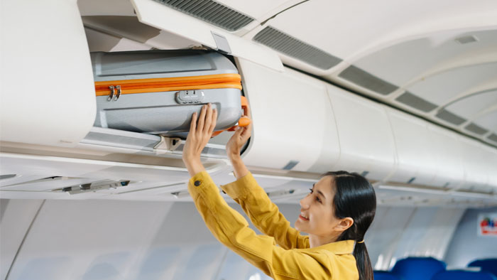 Flight attendant loading luggage
